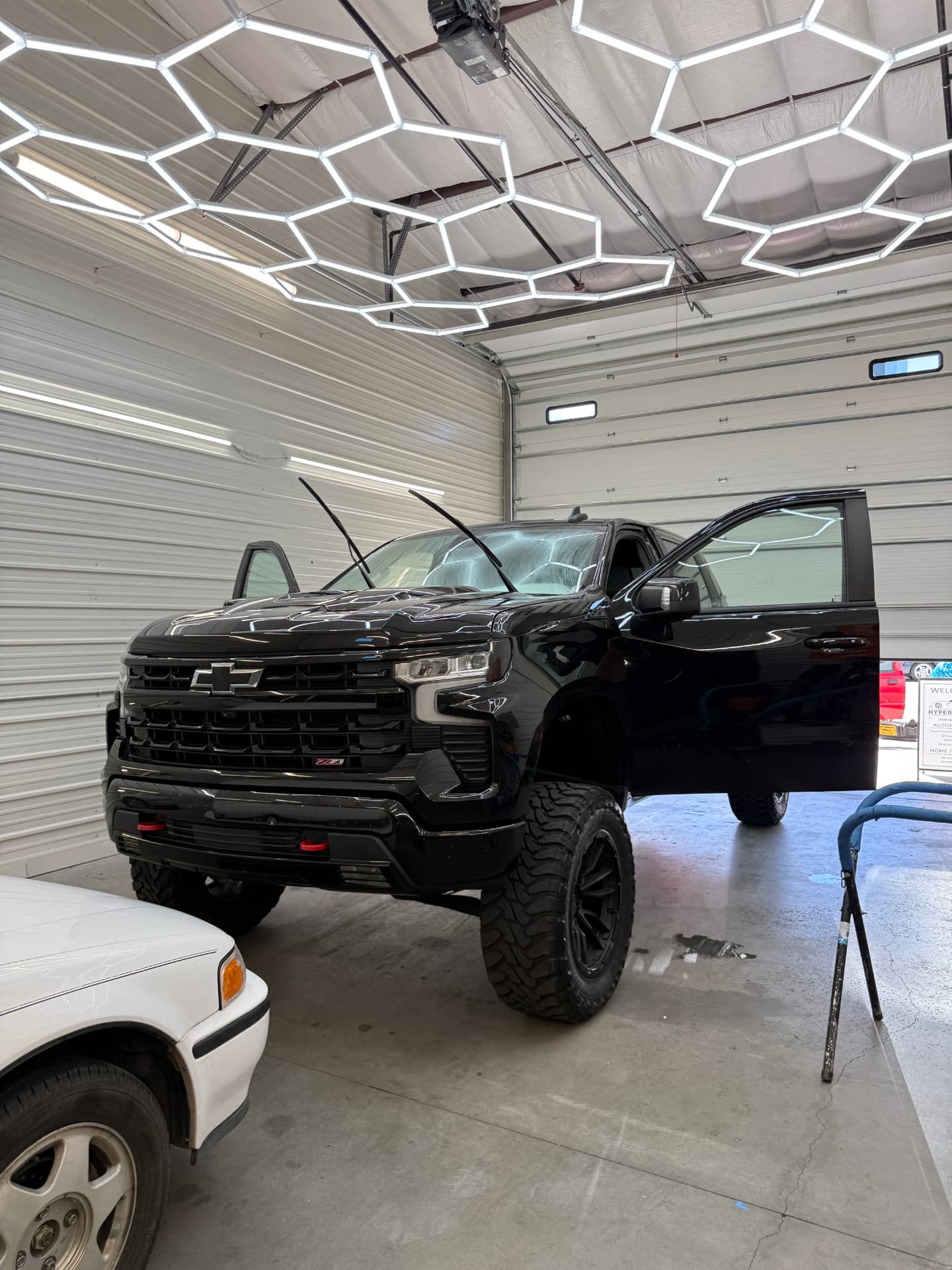 Lifted black Chevrolet Silverado Z71 getting ceramic tint installed in the bay