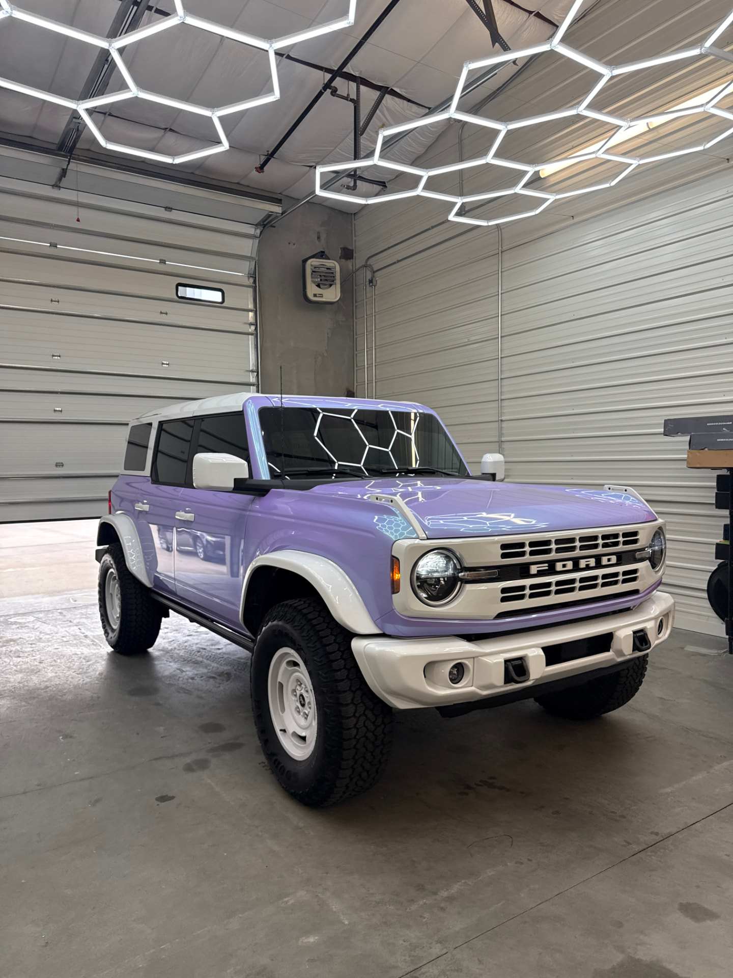 Purple and white Ford Bronco with tinted windows in the install bay