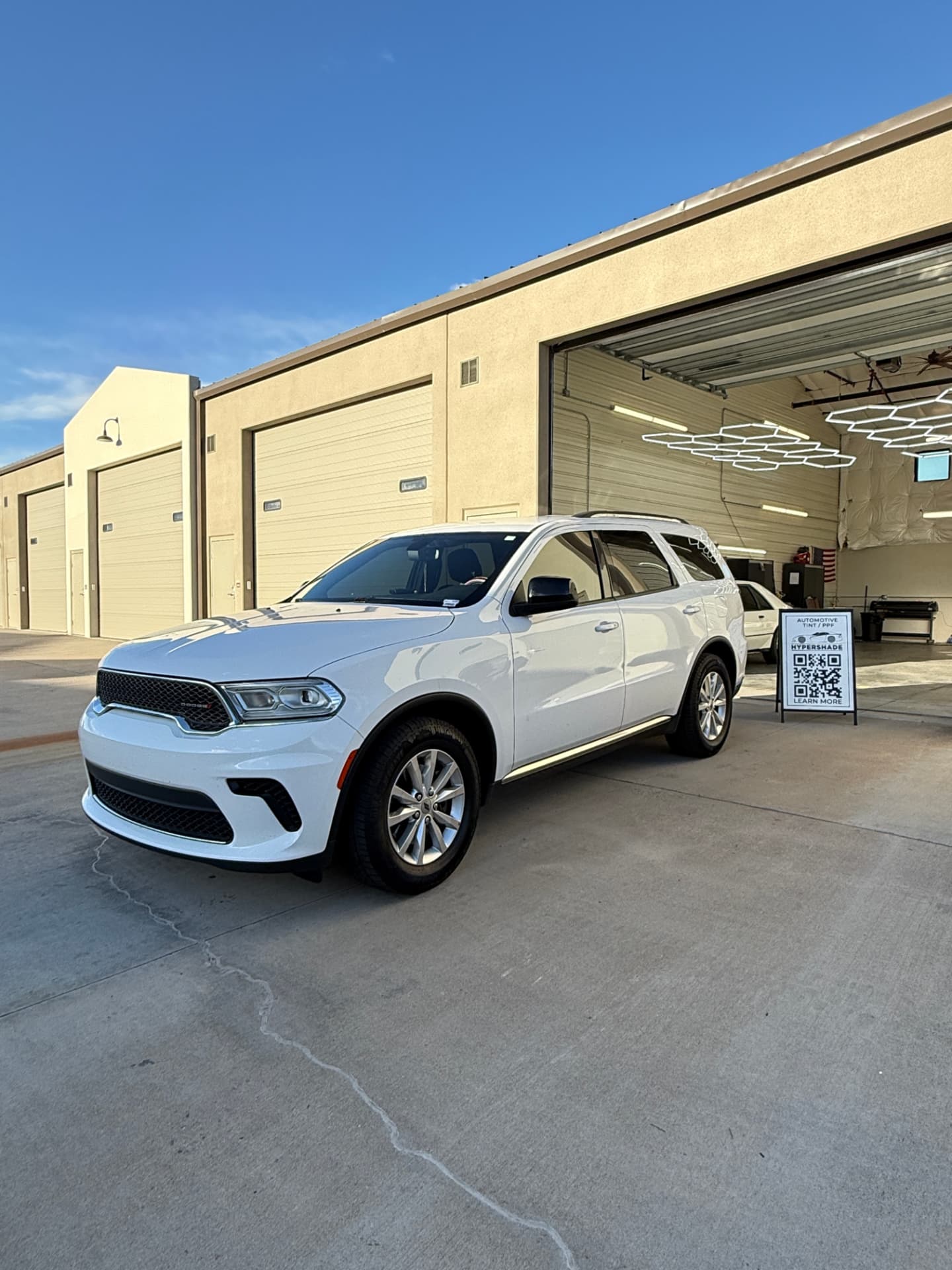 White Dodge Durango with fresh ceramic window tint outside the Castle Rock shop