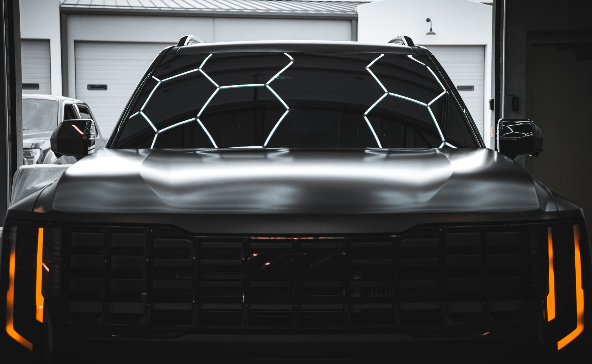 Blacked-out SUV with ceramic windshield tint under the Hypershade hex lighting
