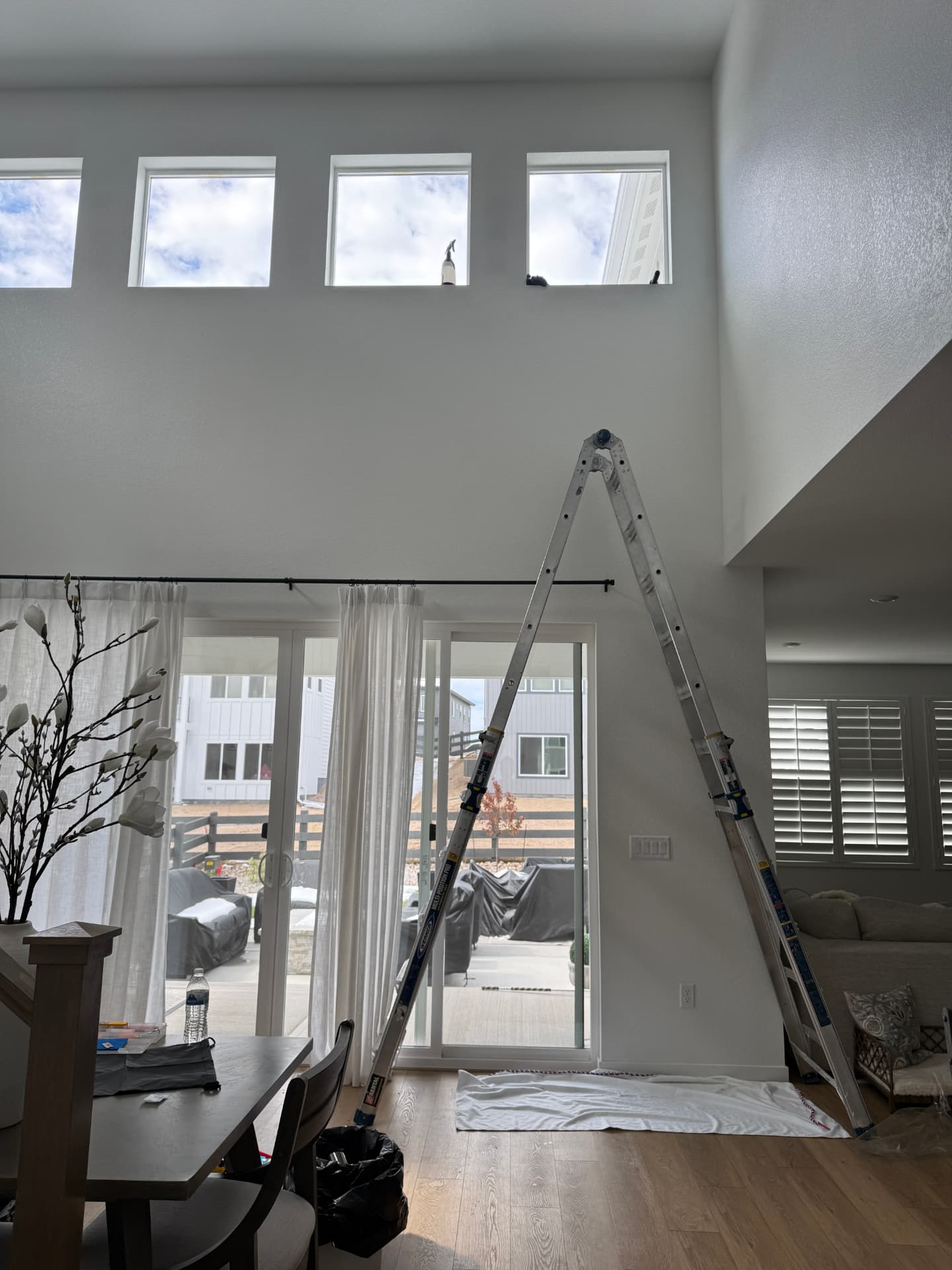 Two-story Colorado great room with clerestory windows getting architectural window film installed