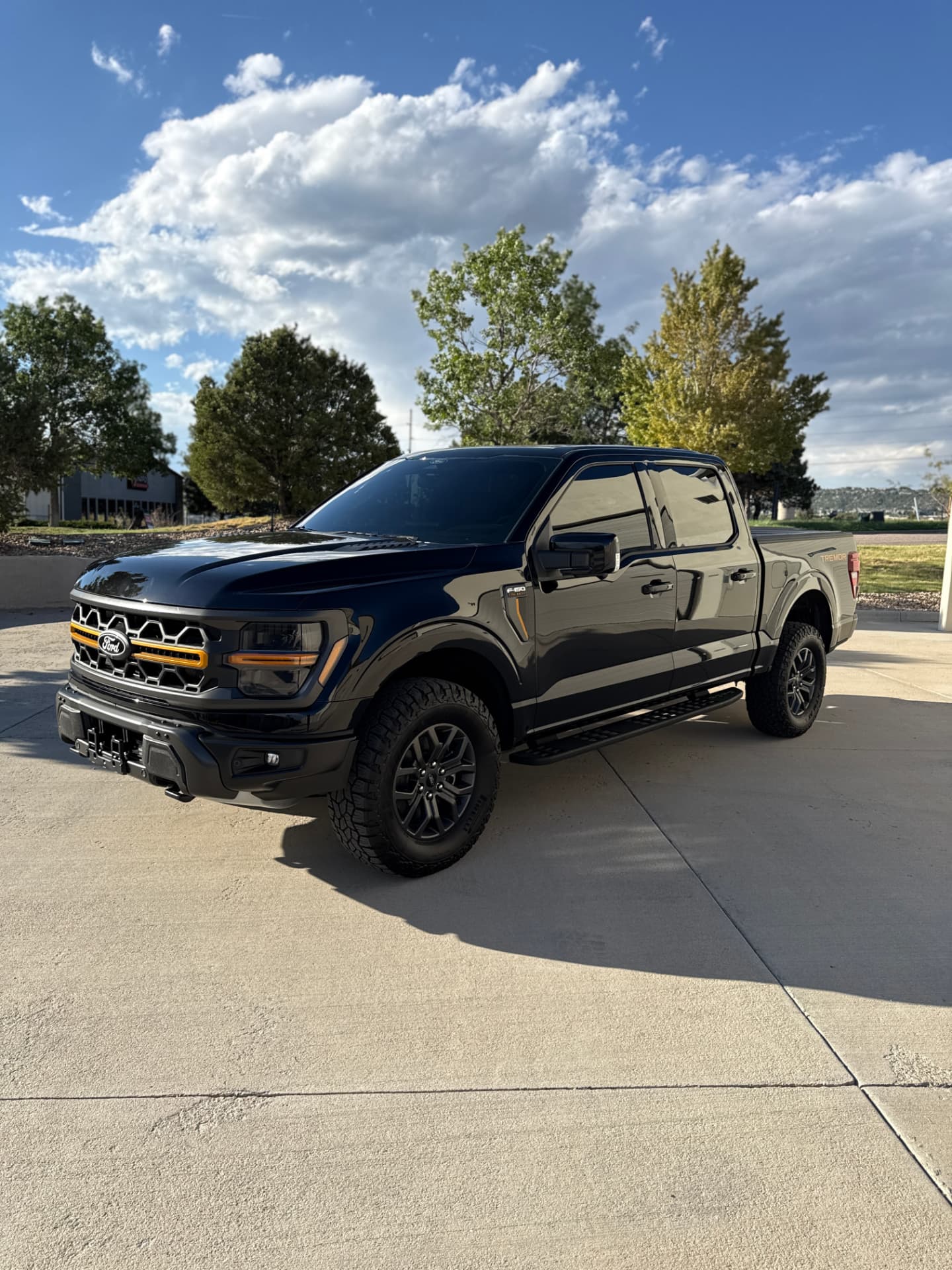 Black Ford F-150 Tremor with ceramic window tint on a sunny Castle Rock day
