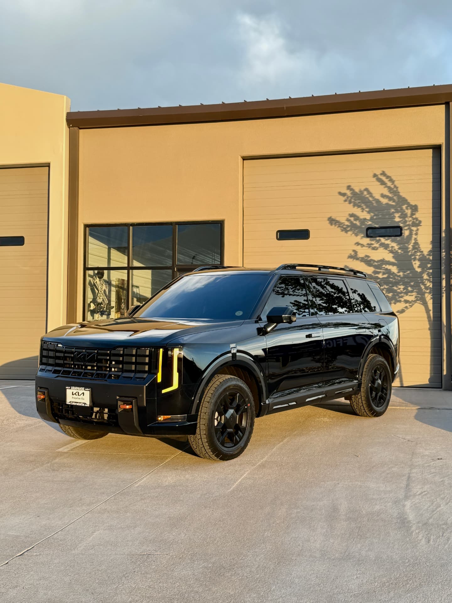 Black Kia Telluride with ceramic window tint outside the Hypershade shop at sunset