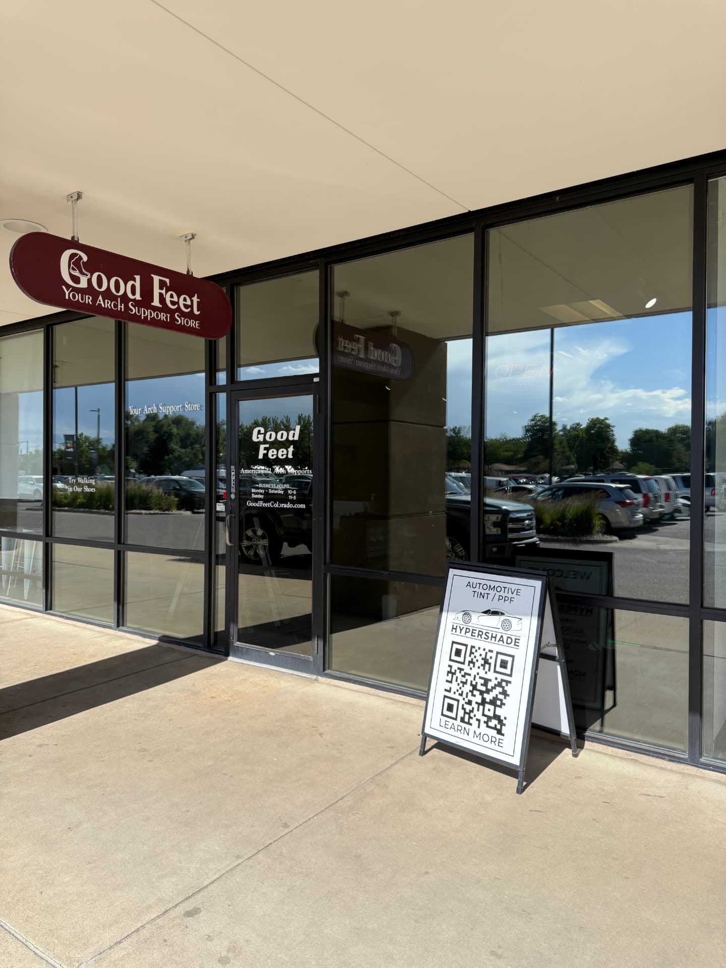 Retail storefront windows with solar control film and a Hypershade automotive tint sign out front