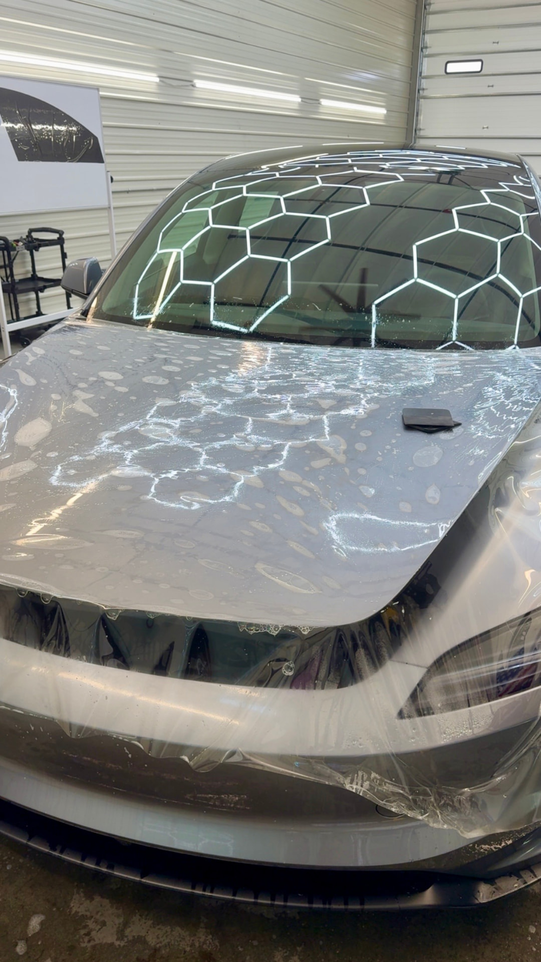 2026 Tesla Model 3 with full front end paint protection film being wet-applied on the hood and bumper in the Hypershade install bay